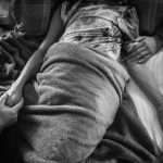 Laurels letzter Atemzug. Die ganze Familie ist bei ihr und signalisiert ihr, daß sie loslassen darf. New York, Dezember 2014. Foto: © Nancy Borowick