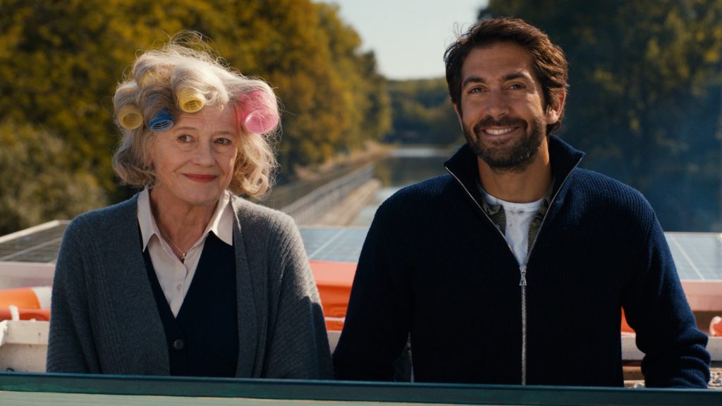 "Fluss des Lebens - Geliebte Loire": Johanna (Lisa Kreuzer) steht mit bunten Lockenwicklern in den Haaren neben Pierre (Mathieu Delarive) an Deck eines Schiffes. Bildquelle:© ZDF und Philipp Timme